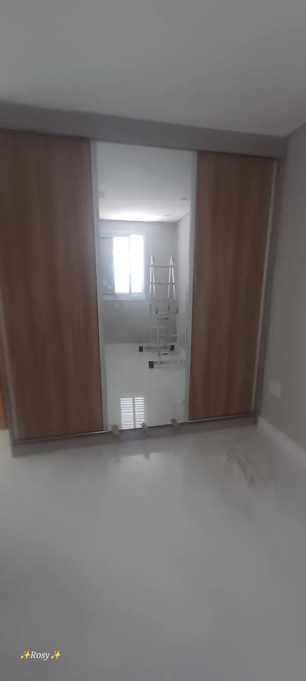 Ambiente residencial com portas de madeira e painel de vidro ao centro