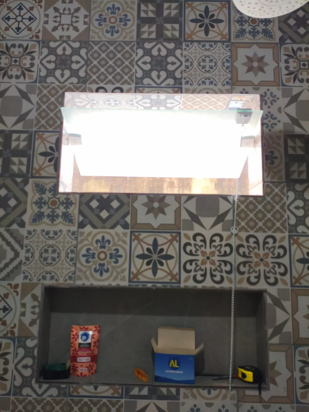 Janela basculante de vidro em parede de banheiro com ladrilho hidráulico
